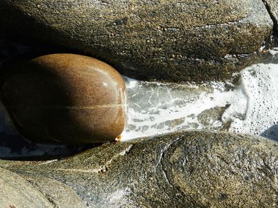 Water flowing smoothly over rocks in a stream.